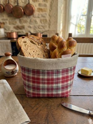 Panière à pain en kelsch alsacien à carreaux rouges posée sur une table en bois – Kelsch d'Alsace In Seebach